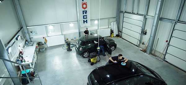Fahrzeugpflegehalle mit zwei Pkw´s und Mitarbeitern